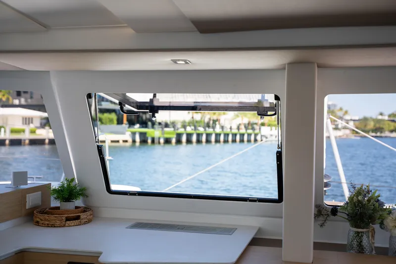 Slide: The Image of Interior view of 2025 Fountaine Pajot New 41 yacht, showcasing window and scenic waterway. - 83