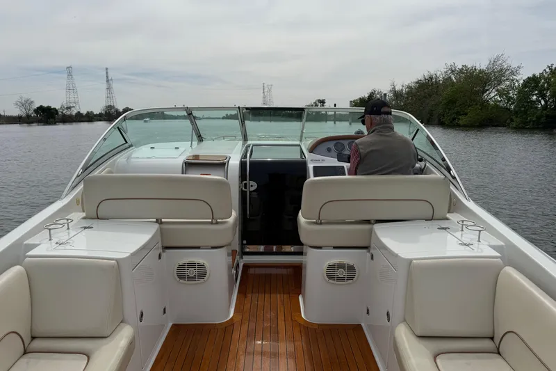 Slide: The Image of 2008 Chris-Craft Corsair 36 Heritage Edition boat interior with captain navigating on calm waters. - 10