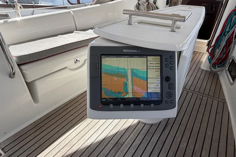 Slide: The Image of Beneteau 43 yacht cockpit with navigation system, 2008 model, featuring wooden flooring and seating. - 28