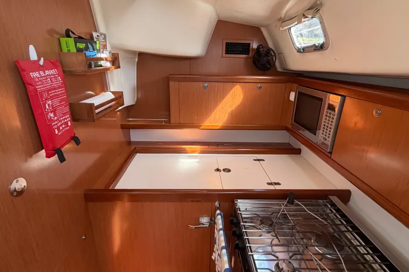 Slide: The Image of Interior of a 2008 Beneteau 43 yacht kitchen with wooden cabinets and appliances. - 41