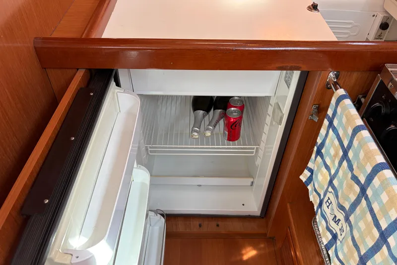 Slide: The Image of Small fridge in 2008 Beneteau 43 yacht galley with drinks and towel. - 43