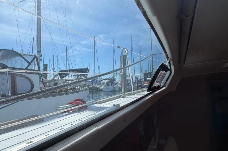 Slide: The Image of View from inside a 2008 Beneteau 43 sailboat, overlooking a marina with docked boats. - 52