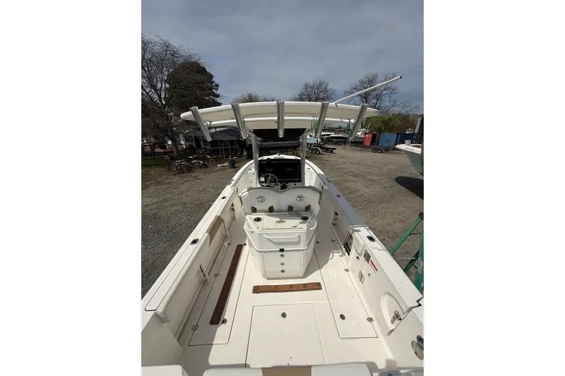 The Image of 2019 Edgewater 262CC boat on trailer, parked outdoors with trees in the background. - 0