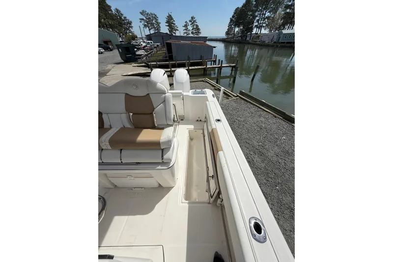 Slide: The Image of 2019 Edgewater 262CC boat interior with storage drawers and sink, docked outdoors. - 12