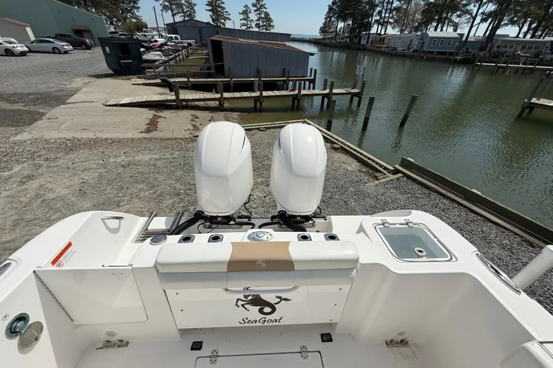 Slide: The Image of 2019 Edgewater 262CC boat interior with seating, docked by a calm waterfront. - 15