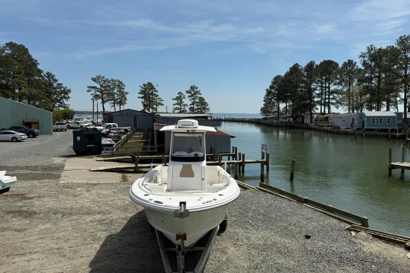 Slide: The Image of 2019 Edgewater 262CC boat interior with dual engines, docked by a calm waterfront. - 16