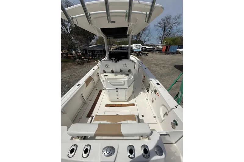 Slide: The Image of 2019 Edgewater 262CC boat docked by a serene waterfront with trees. - 17