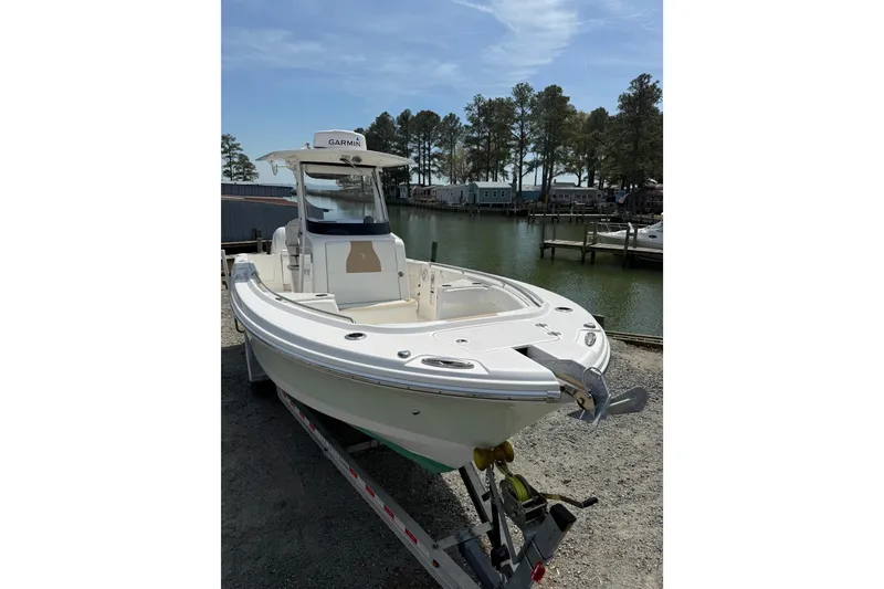 Slide: The Image of 2019 Edgewater 262CC boat on trailer by a scenic waterfront. - 24