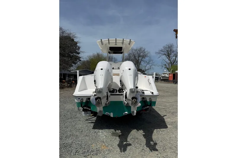 Slide: The Image of 2019 Edgewater 262CC boat with dual outboard motors docked near a serene waterfront. - 26