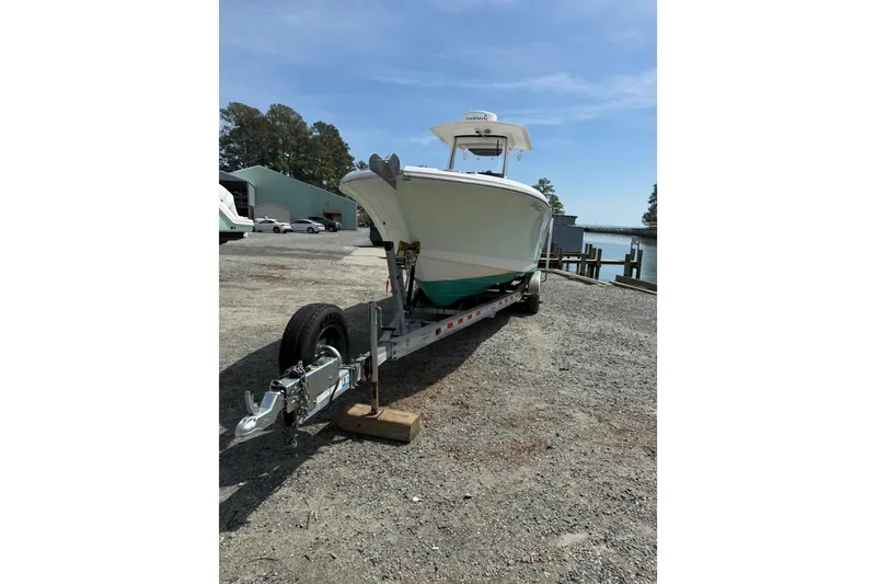 Slide: The Image of 2019 Edgewater 262CC boat with dual outboard motors, parked on gravel. - 29
