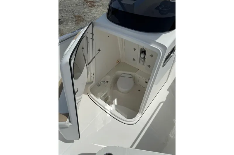 Slide: The Image of 2019 Edgewater 262CC boat docked near a serene waterfront with trees. - 4