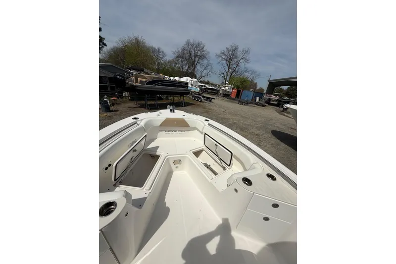 Slide: The Image of 2019 Edgewater 262CC boat with Garmin equipment, docked by a serene waterfront. - 6