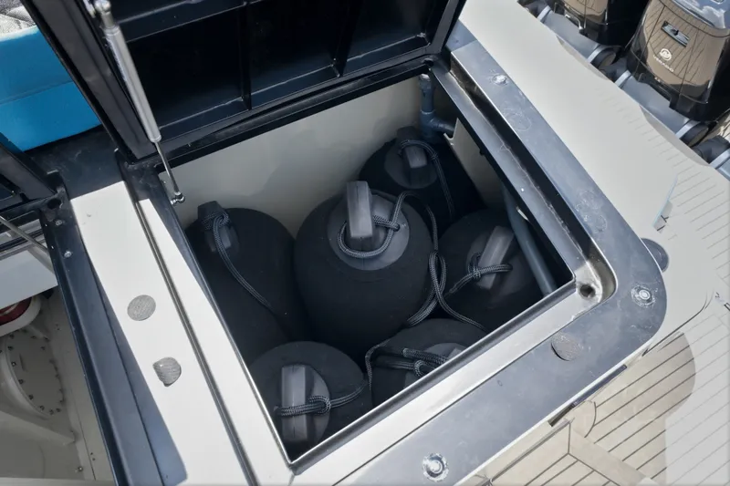 Slide: The Image of Storage compartment on a 2026 Dutch American DA 53 boat, containing black fenders. - 62