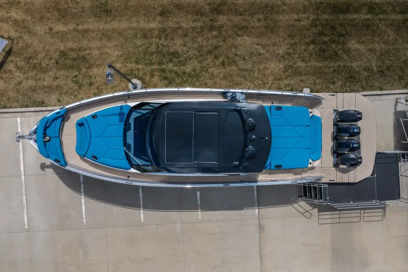 Slide: The Image of Aerial view of 2026 Dutch American DA 53 boat with blue seating and triple outboard motors. - 4