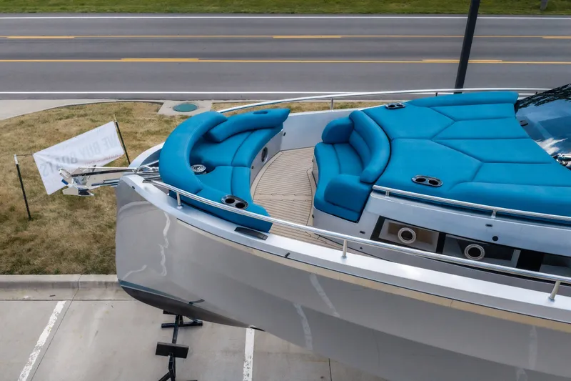 Slide: The Image of Luxurious 2026 Dutch American DA 53 yacht with blue seating, docked near a road. - 2