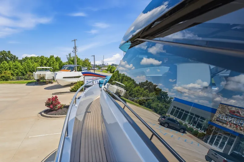 Slide: The Image of 2026 Dutch American DA 53 yacht reflecting sky, parked near dealership with other boats. - 52