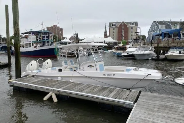 Slide: The Image of 2020 Twin Vee 260 CC SE boat docked in a marina with other vessels. - 8