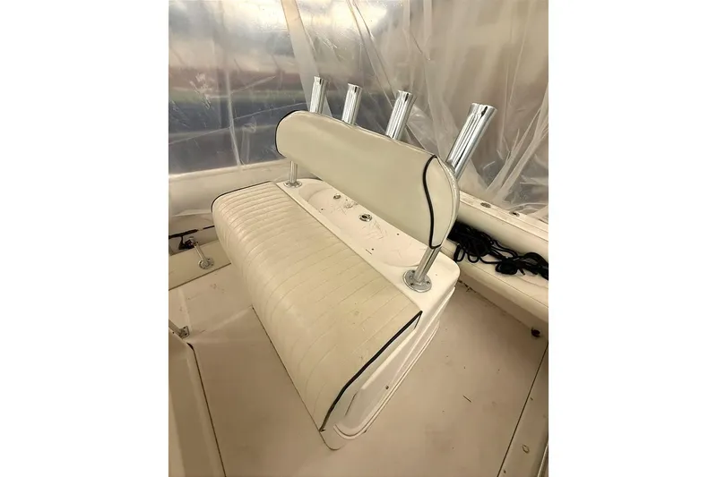 Slide: The Image of 2005 Robalo R220 Center Console boat seat with rod holders, featuring white upholstery. - 4