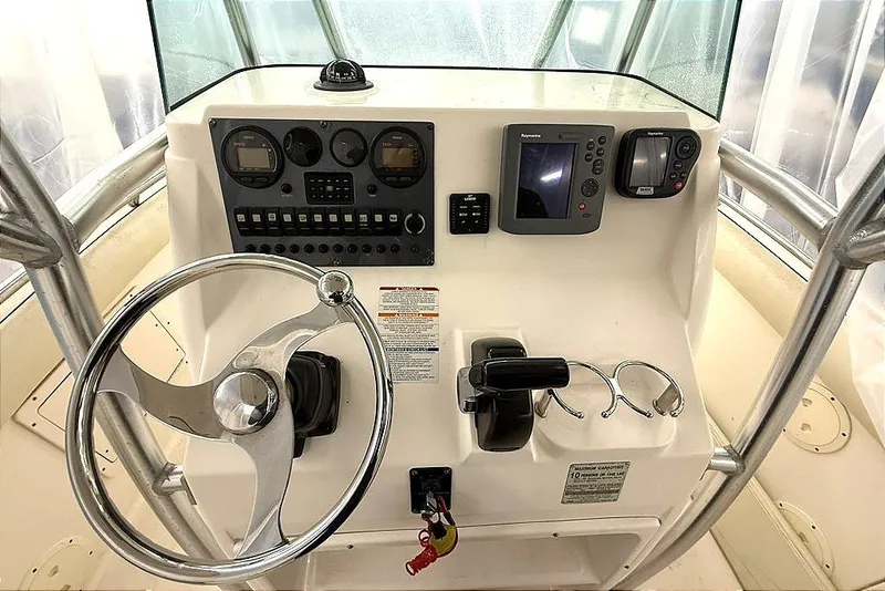 Slide: The Image of 2005 Robalo R220 Center Console boat dashboard with steering wheel and navigation instruments. - 5