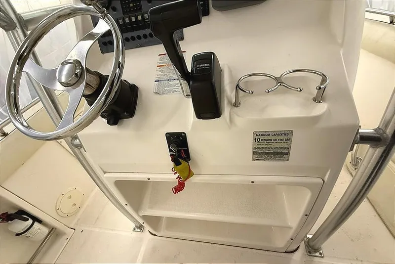 Slide: The Image of 2005 Robalo R220 Center Console helm with steering wheel, controls, and cup holders. - 8
