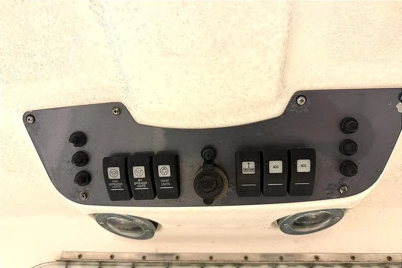 Slide: The Image of Control panel of a 2005 Robalo R220 Center Console boat with switches and 12V outlet. - 9