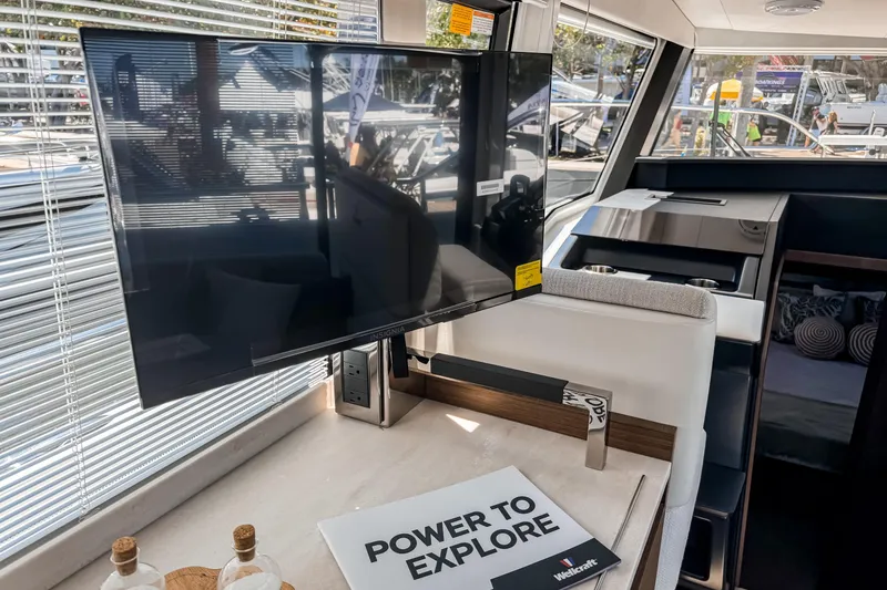 Slide: The Image of Interior of 2026 Wellcraft 44 Explorer yacht with TV and "Power to Explore" brochure. - 21