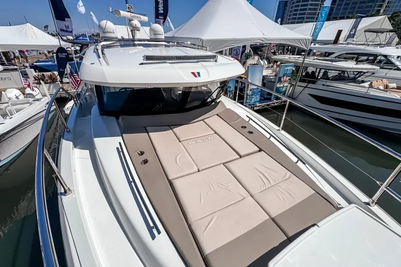 Slide: The Image of 2026 Wellcraft 44 Explorer yacht at a boat show, featuring a spacious sun deck. - 47