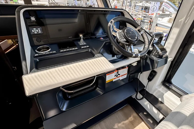 Slide: The Image of 2026 Wellcraft 44 Explorer helm with advanced navigation controls and sleek steering wheel. - 26