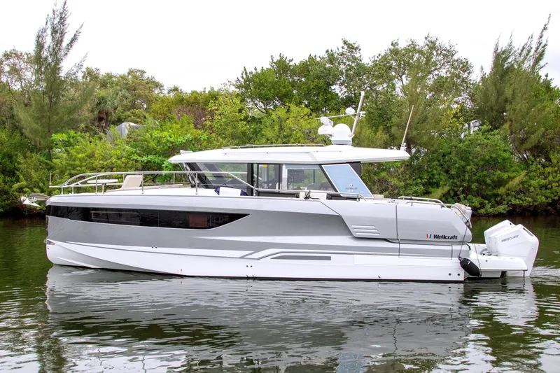 Slide: The Image of 2026 Wellcraft 44 Explorer yacht on calm water, surrounded by lush greenery. - 50