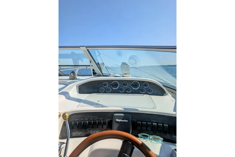 Slide: The Image of 1998 Sea Ray Sundancer 330 dashboard view with gauges and steering wheel on open water. - 4