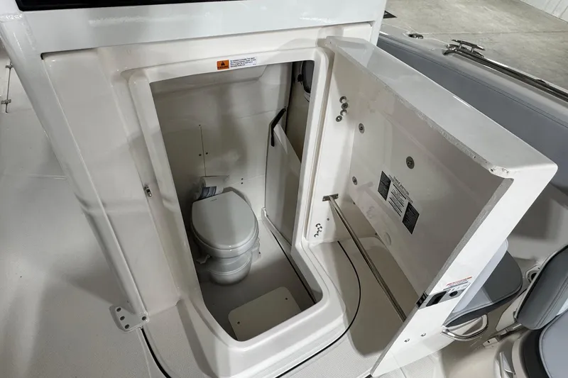 Slide: The Image of 2025 Robalo R360 Center Console boat interior with compact marine toilet. - 10