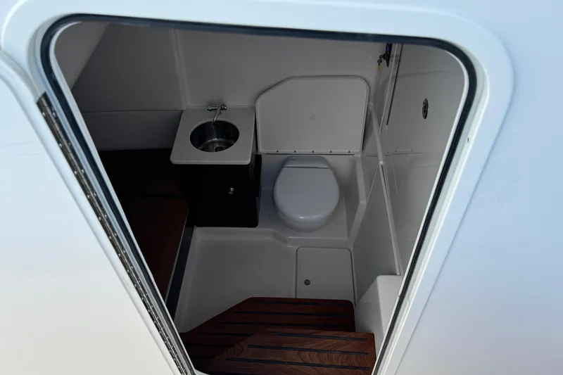Slide: The Image of 2025 Robalo R360 Center Console boat interior bathroom with sink and toilet. - 29