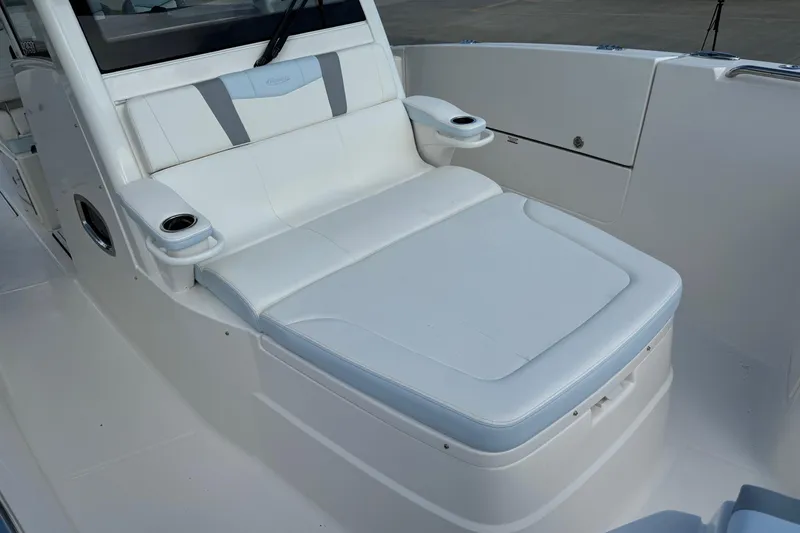 Slide: The Image of 2025 Robalo R360 Center Console boat with white cushioned seating and cup holders. - 34