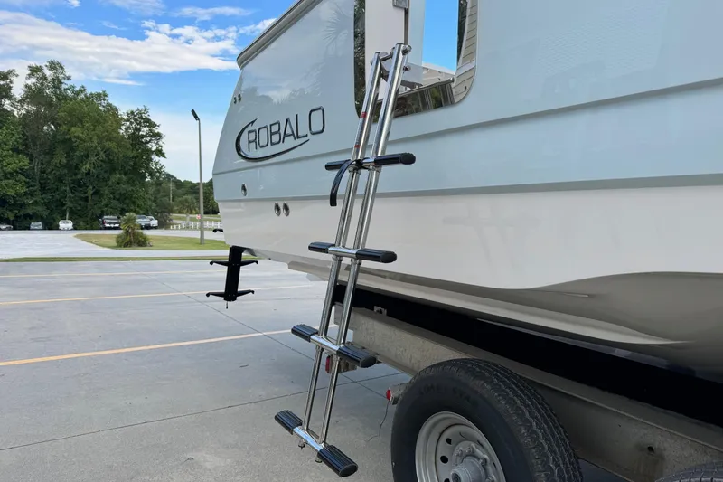 Slide: The Image of 2025 Robalo R360 Center Console boat on trailer with ladder, parked outdoors. - 4