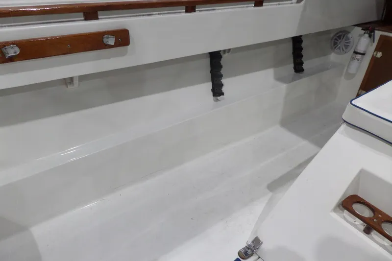 Slide: The Image of 1980 Lyman-Morse Fisherman Sleeper boat interior with white seating and wooden accents. - 12