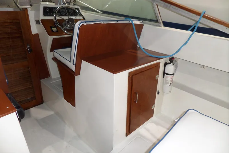 Slide: The Image of 1980 Lyman-Morse Fisherman Sleeper boat interior with wooden cabinetry and steering wheel. - 14