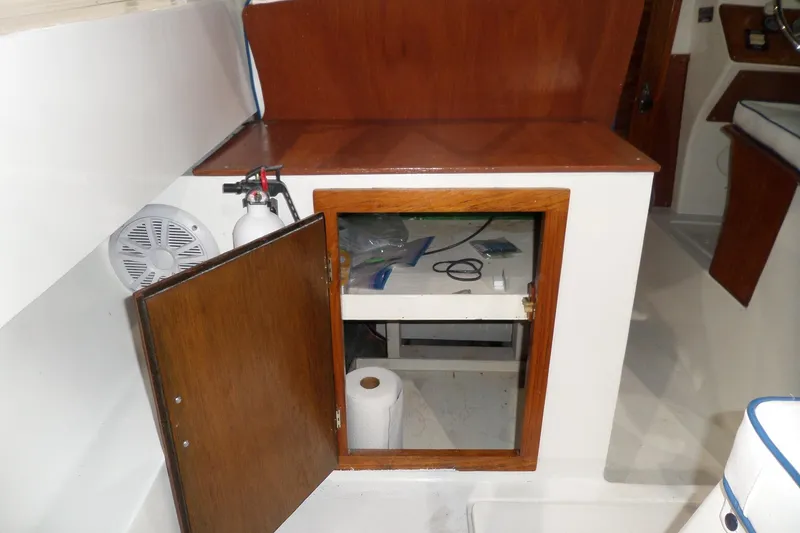 Slide: The Image of Interior of 1980 Lyman-Morse Fisherman Sleeper with open wooden cabinet and fire extinguisher. - 15