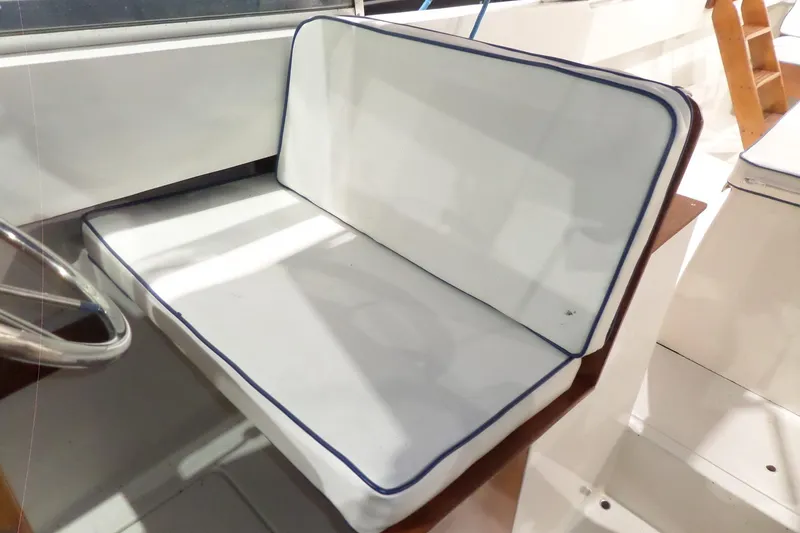 Slide: The Image of White cushioned seat on 1980 Lyman-Morse Fisherman Sleeper boat, with blue trim. - 26