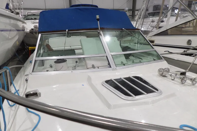 Slide: The Image of 1980 Lyman-Morse Fisherman Sleeper boat with blue canopy in storage. - 45