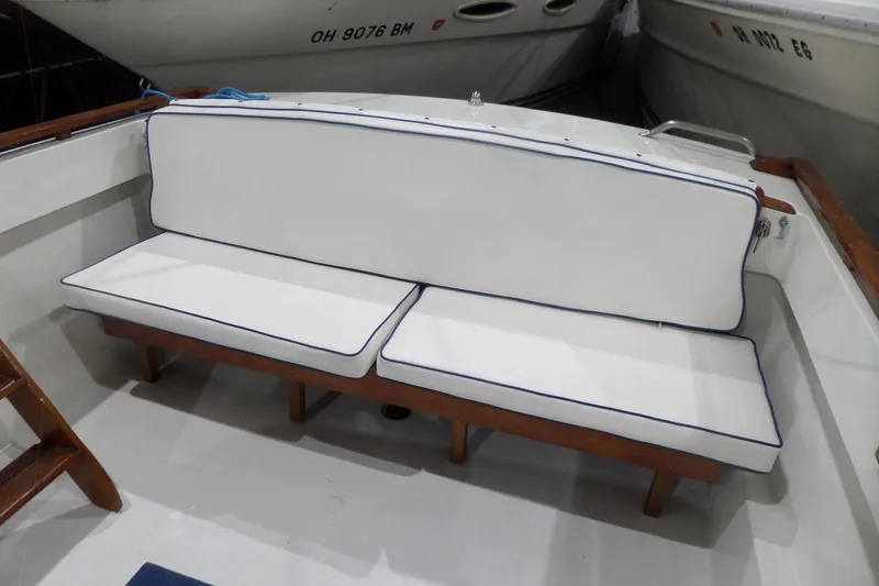 Slide: The Image of White cushioned seating on 1980 Lyman-Morse Fisherman Sleeper boat, docked between vessels. - 7