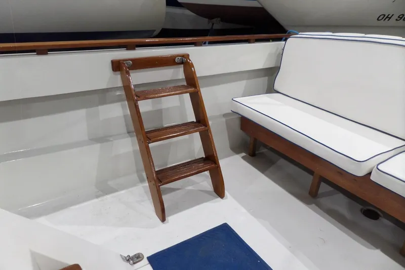 Slide: The Image of Wooden ladder and cushioned seating on 1980 Lyman-Morse Fisherman Sleeper boat deck. - 8