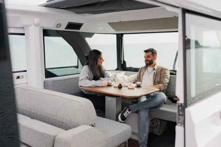 Slide: The Image of Couple enjoying coffee inside 2027 Axopar 38 Cross Cabin boat. - 11