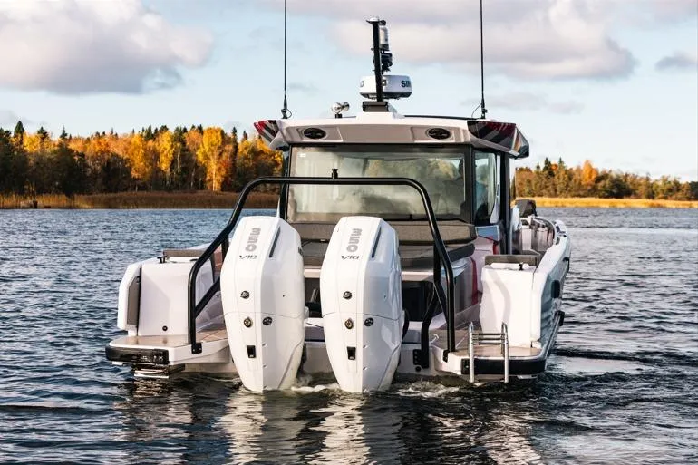 Slide: The Image of 2027 Axopar 38 Cross Cabin boat with dual engines on a scenic lake. - 2