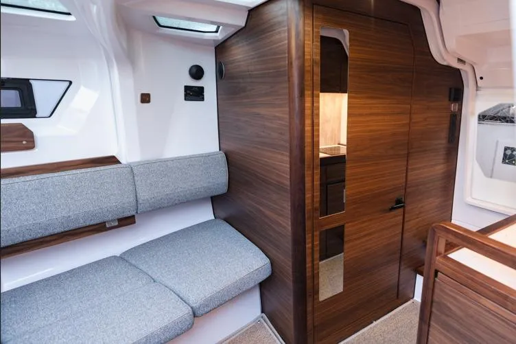 Slide: The Image of Interior of 2027 Axopar 38 Cross Cabin with modern seating and wooden cabinetry. - 3