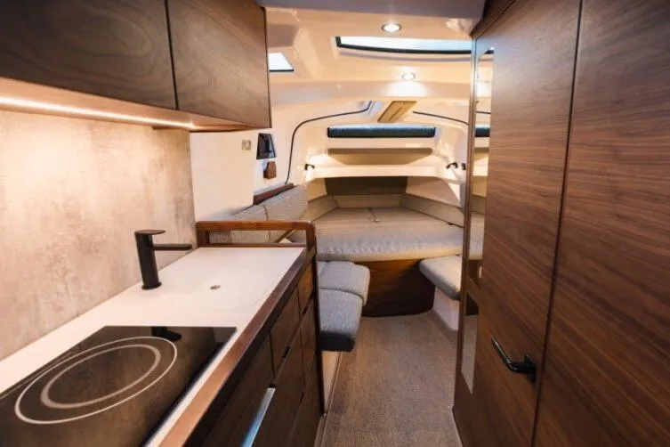 Slide: The Image of Luxurious interior of 2027 Axopar 38 Cross Cabin with modern kitchen and cozy seating area. - 4