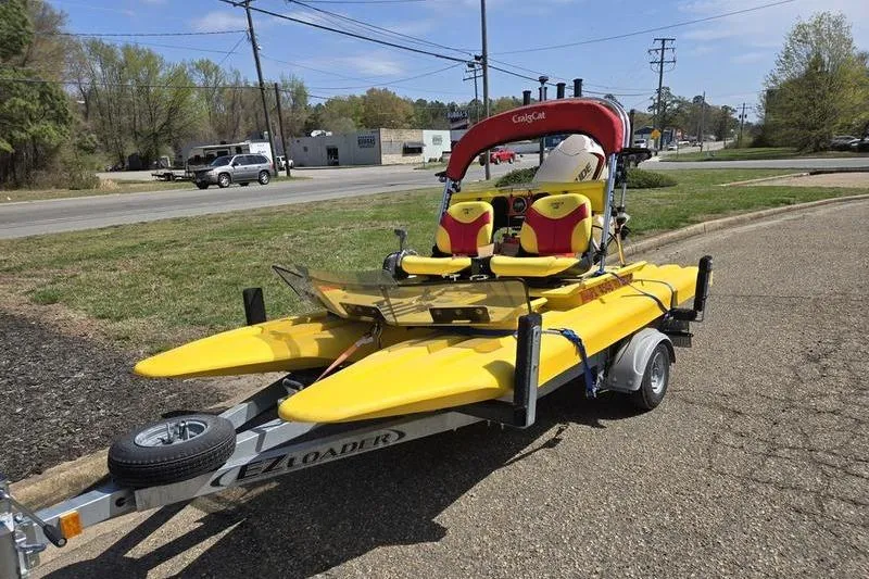 The Image of Yellow 2019 CraigCat CATCHIT boat on trailer, parked roadside under clear sky. - 0