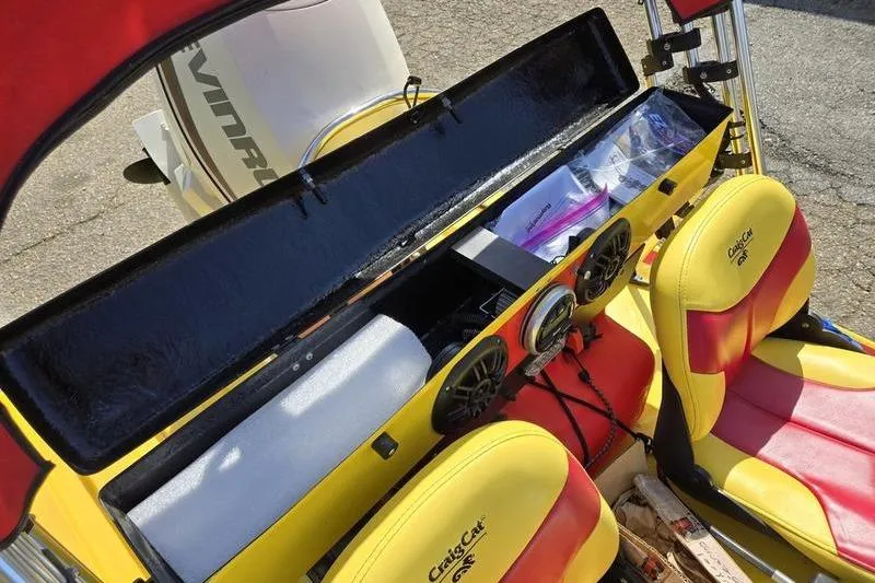 Slide: The Image of 2019 CraigCat CATCHIT interior with yellow and red seats, open storage, and dashboard controls. - 10