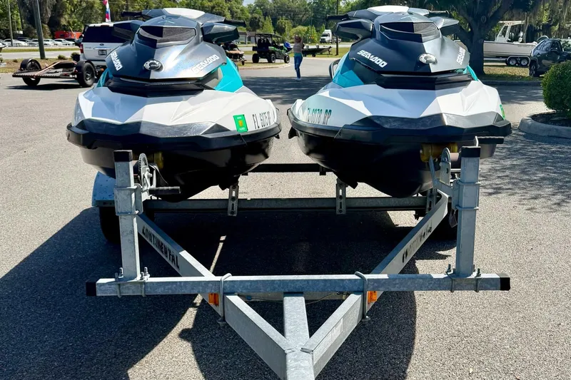 Slide: The Image of Two 2018 Sea-Doo GTS jet skis on a trailer in a parking lot. - 2