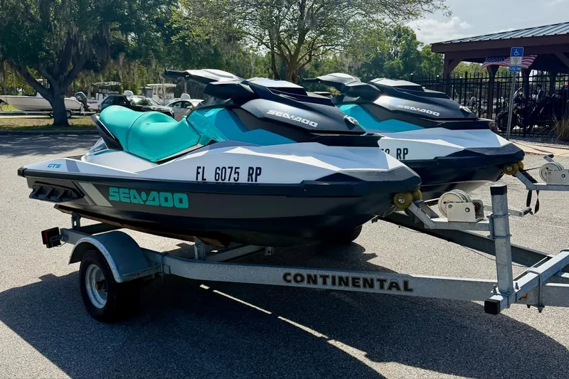 Slide: The Image of 2018 Sea-Doo GTS jet skis on a trailer in a parking lot. - 3