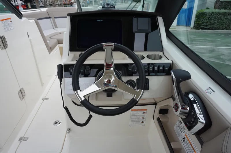 Slide: The Image of 2026 Boston Whaler 240 Vantage helm with steering wheel and control panel. - 21